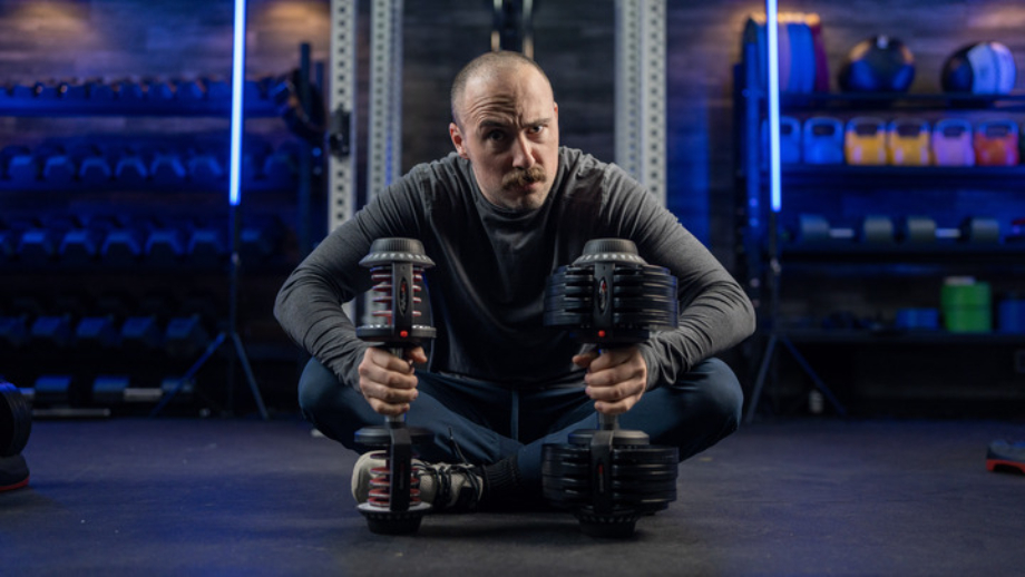 Man holding the Ativafit Adjustable Dumbbells