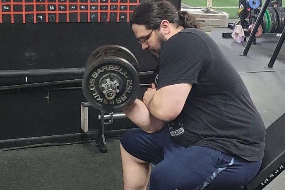 A man performing concentration curls with the Titan loadable dumbbells