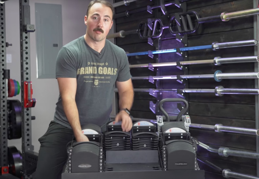 Coop standing in his garage gym with PowerBlock Dumbbells