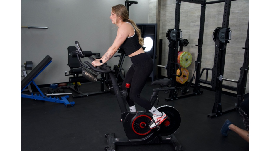 woman standing up riding the echelon ex5 bike