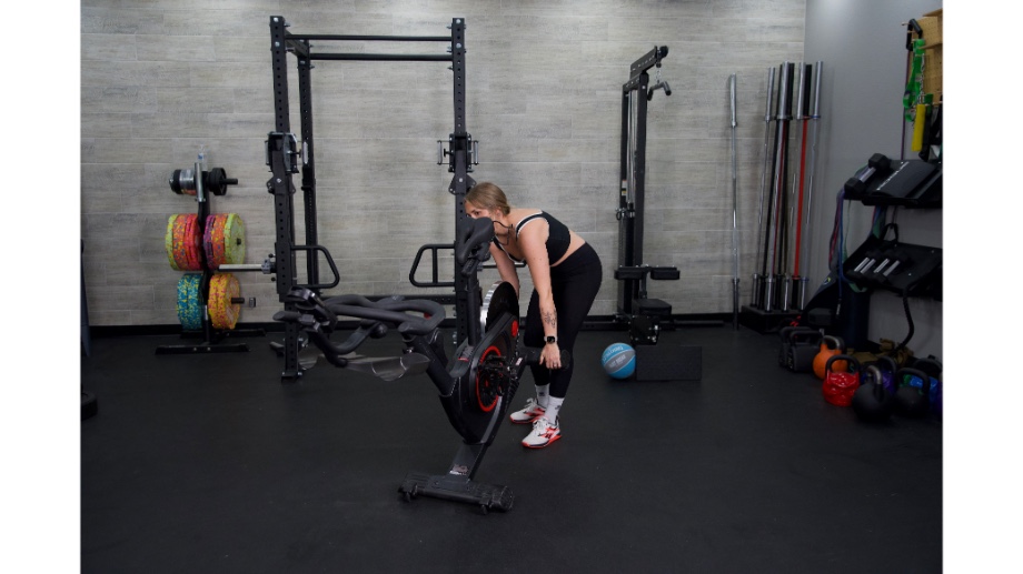 An image of a woman moving the Echelon EX-5 bike