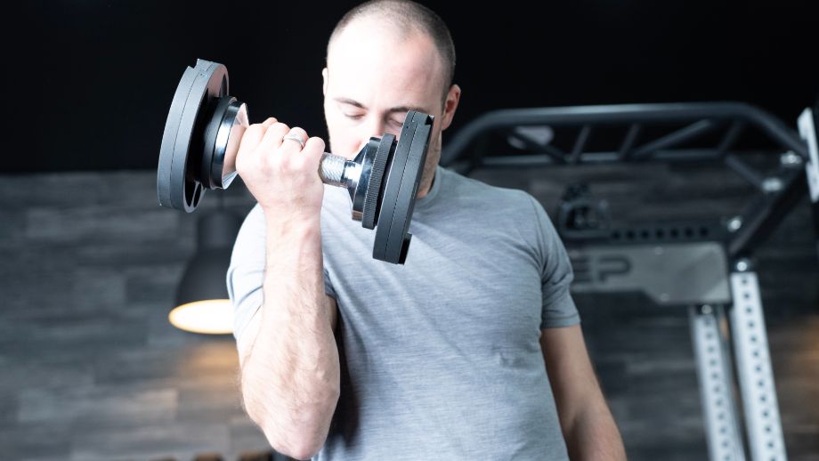 Man doing a biceps curl with the Snode AD80 adjustable dumbbells