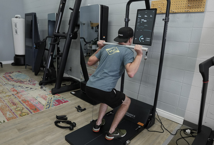 A man wearing athletic gear doing back squats using a Speediance Home Gym