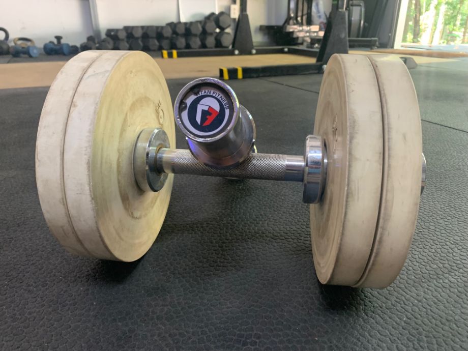 Titan Loadable dumbbells with weight loaded and laying on a gym floor