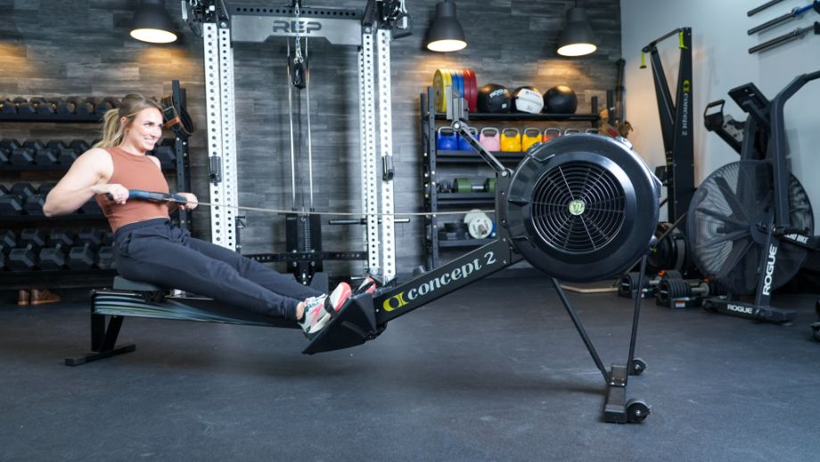 Woman in athletic gear using a Concept2 RowErg in a gym setting